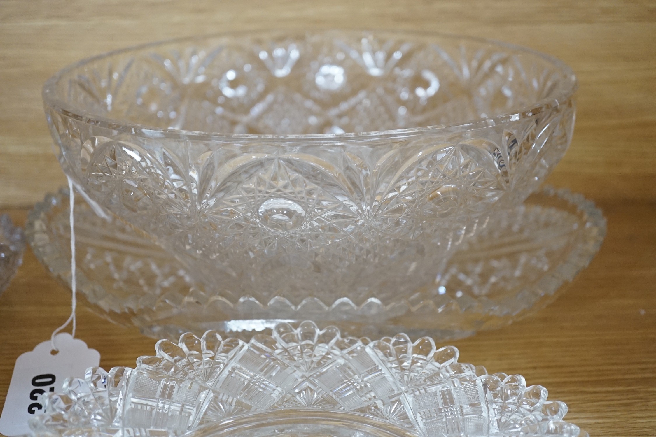 Eight 19th century cut glass circular plates probably Irish, a similar octagonal dish, a later oval cut glass dish and a similar punch bowl, bowl 26 cms diameter